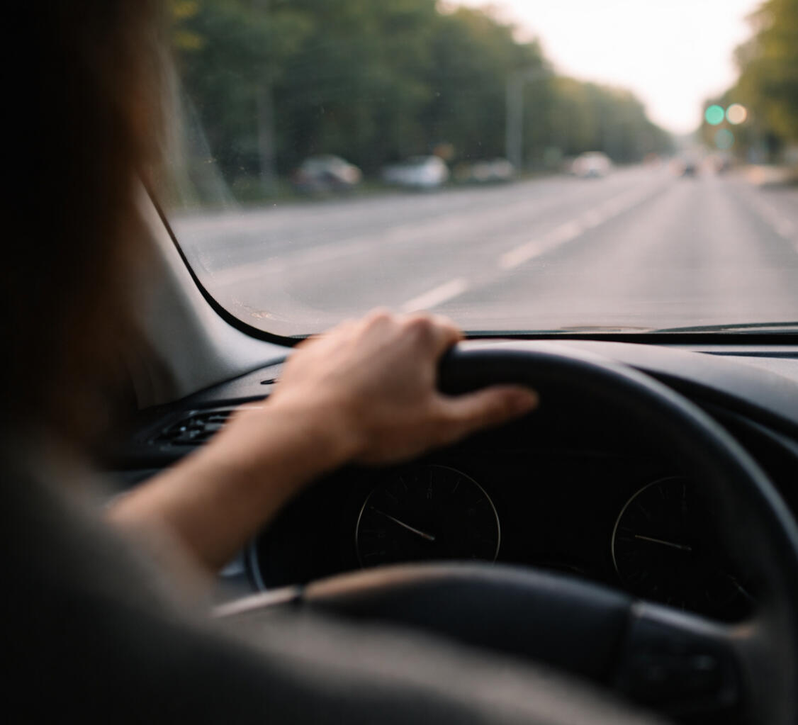 Knowing the direction but unsure about the next move Driver holding the steering wheel while looking down the road symbolizing a leader deciding the next direction